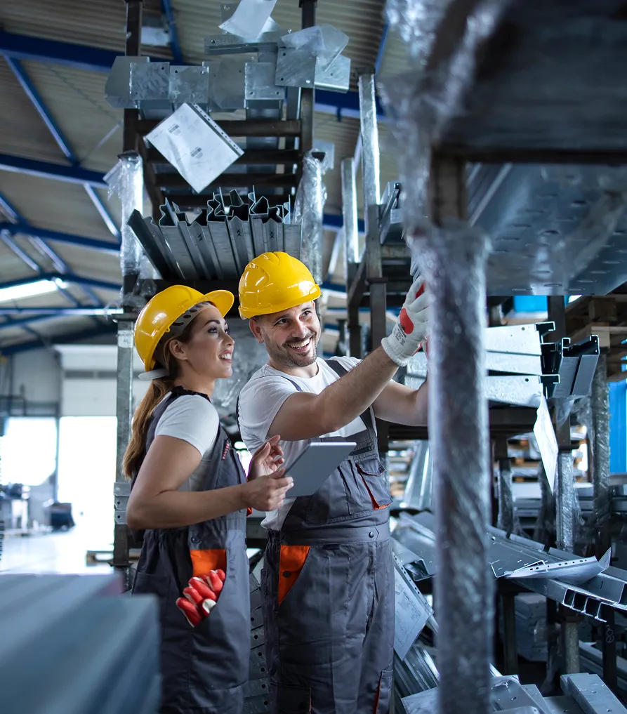 Industrial workers inspecting metal components in a manufacturing facility, emphasizing safety and quality control at NuReady Health Network.