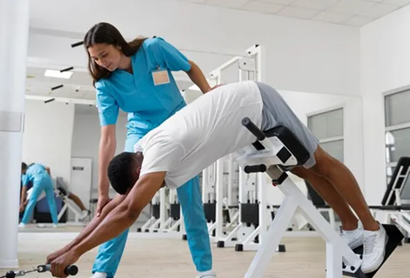 Personal trainer assisting a client with stretching exercise at NuReady Health Network fitness center, promoting health, wellness, and personalized fitness solutions.